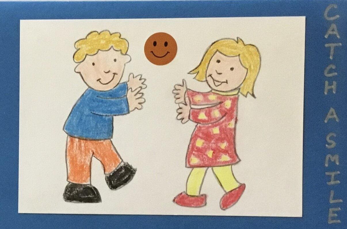 Drawing of a boy and a girl playing with a ball. On the card is written Catch a smile.