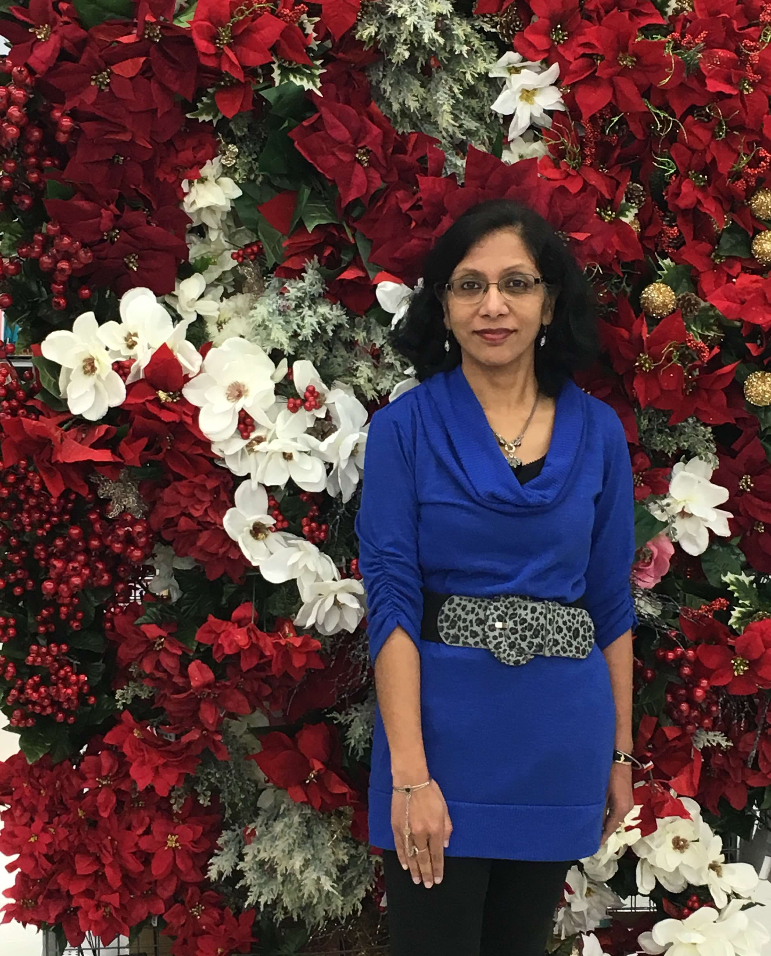 Photograph of Sumita Bose surrounded by flowers.