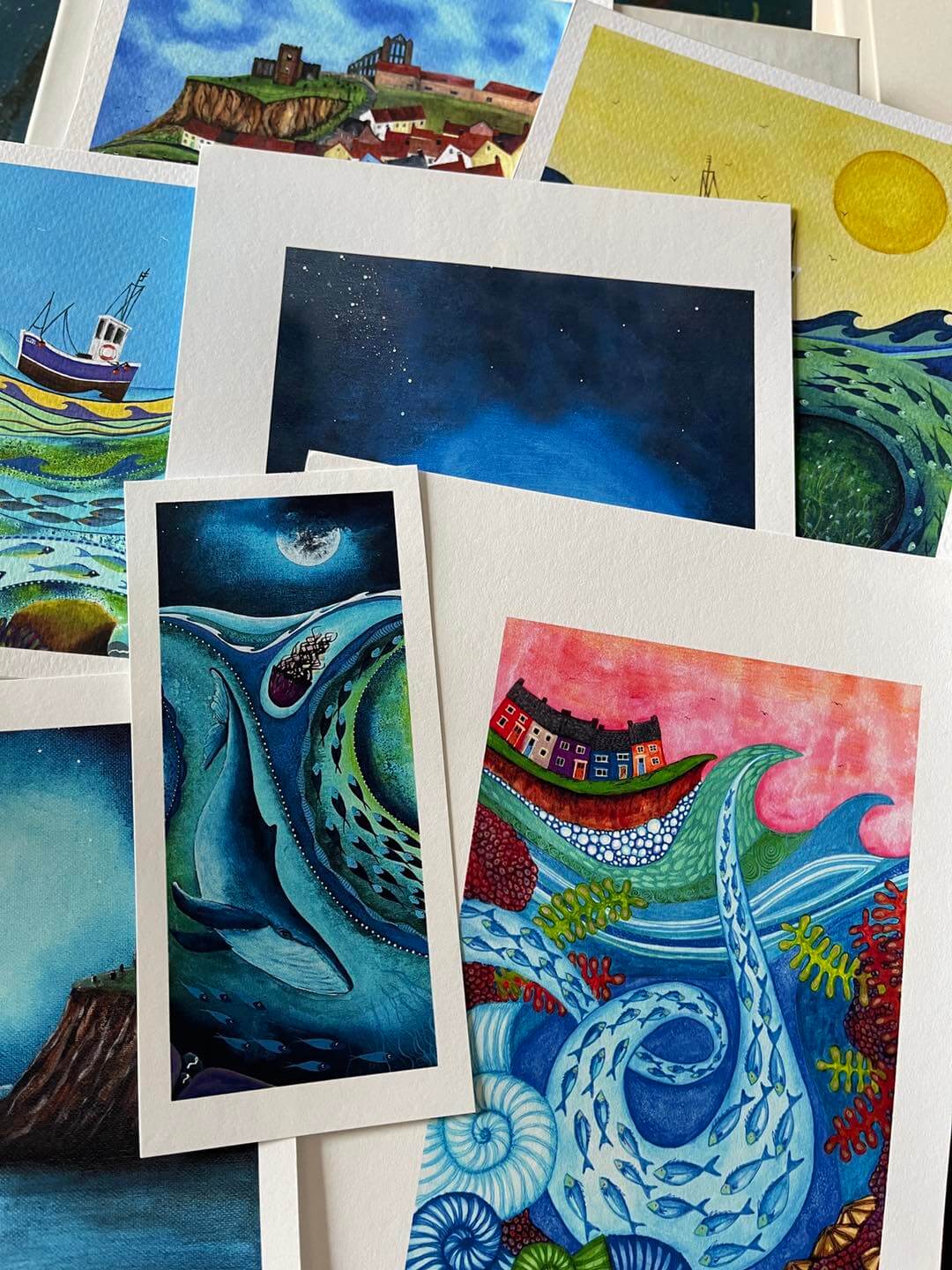Photograph of varied paintings by sea-inspired artist Bridget Wilkinson.