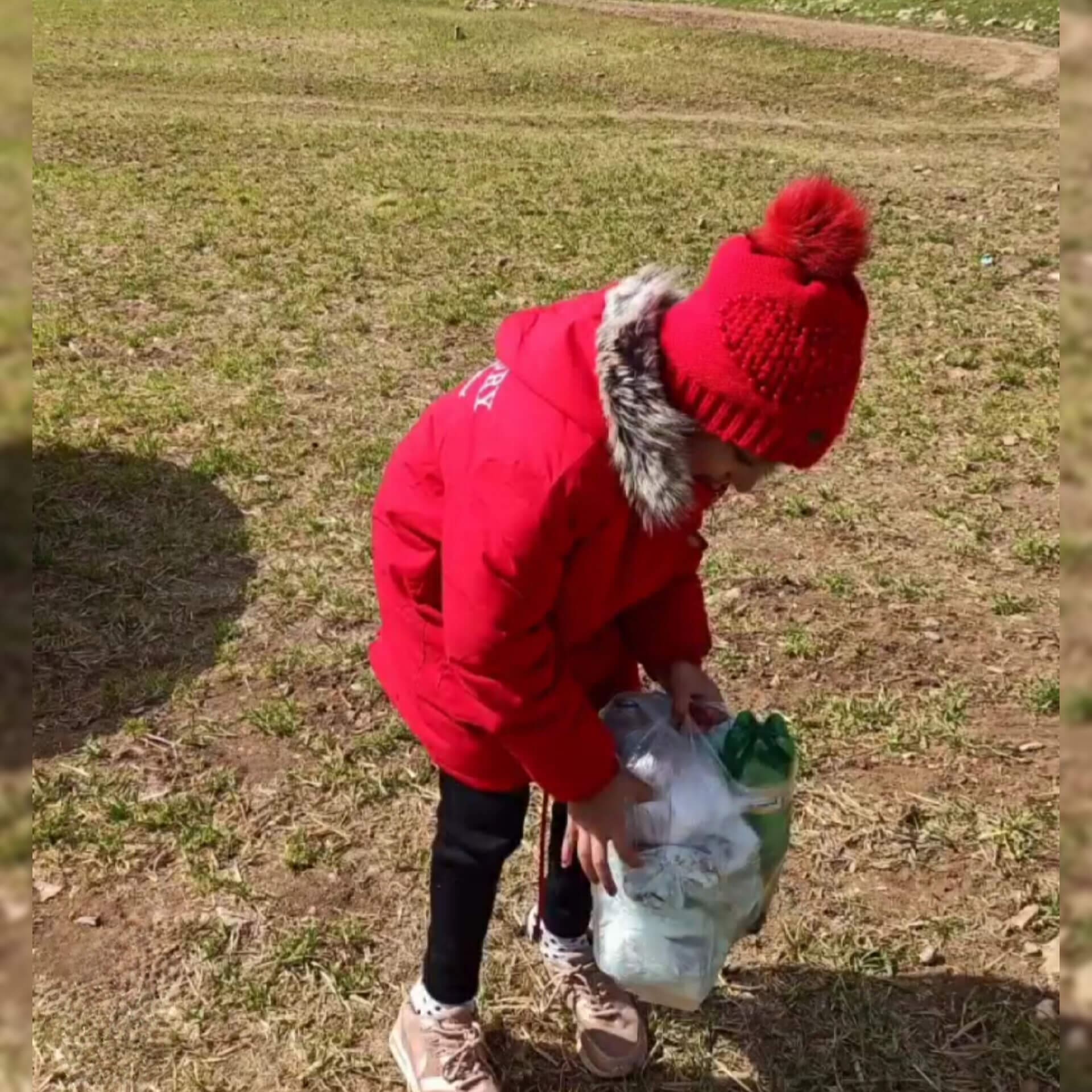 Photograph of the young ambassador for the environment, Baran Fateminejad, from Iran, age 9, cleaning up plastic waste.