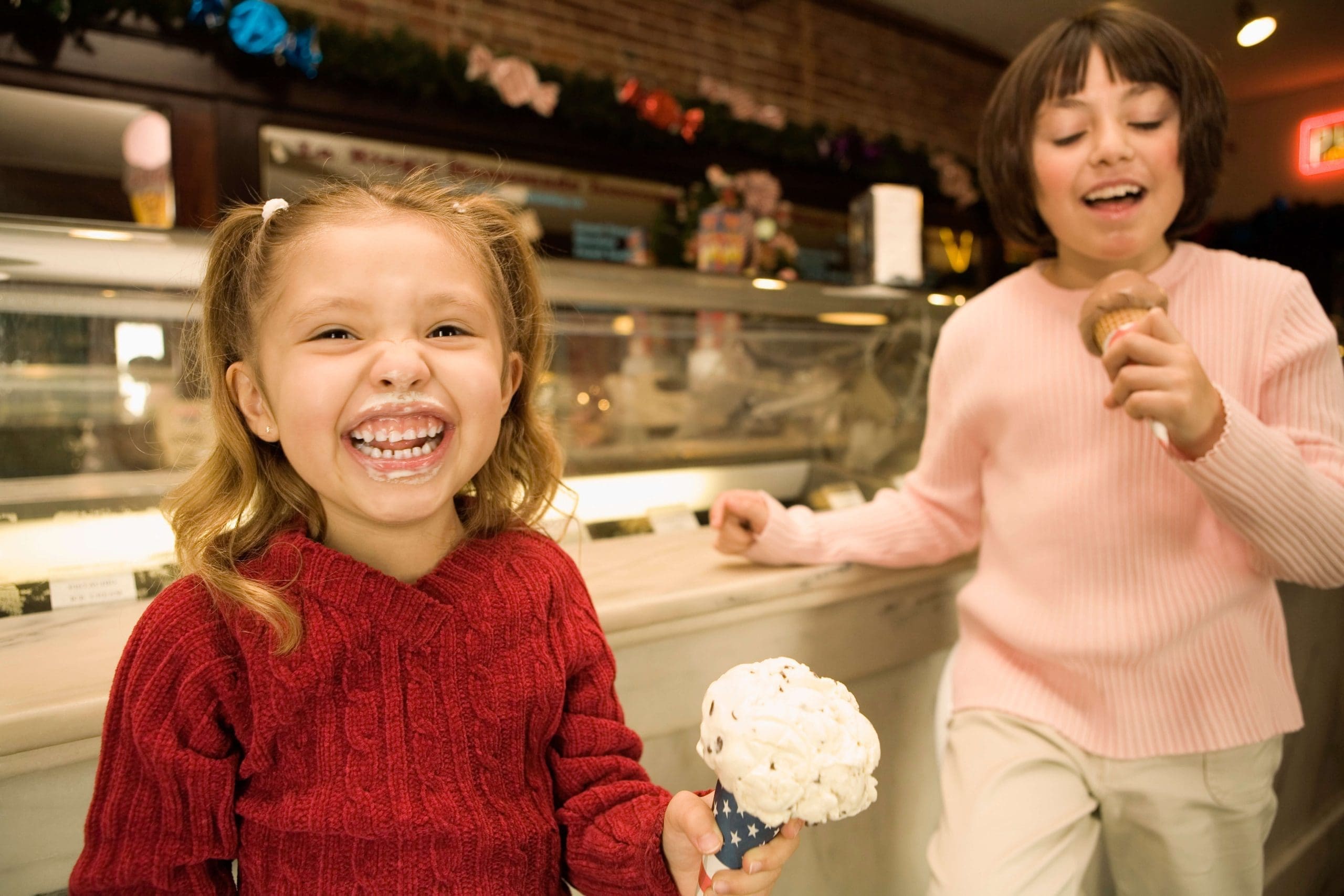 Photograph of two young girls having fun in a ice cream shop.