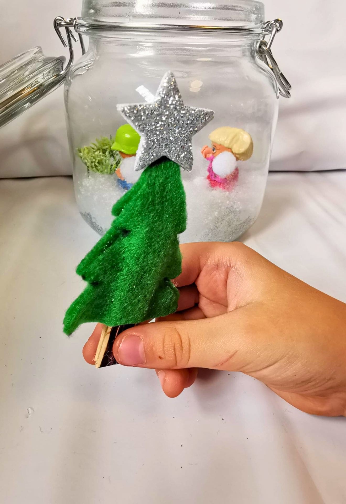winterlandscape in jar child adding evergreen tree